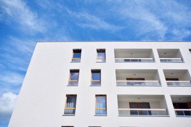 Mavi gökyüzü ve bulutlar ile modern daire binası. Modern çok katlı lüks konut konsepti.