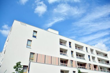 Mavi gökyüzü ve bulutlar ile modern daire binası. Modern çok katlı lüks konut konsepti.