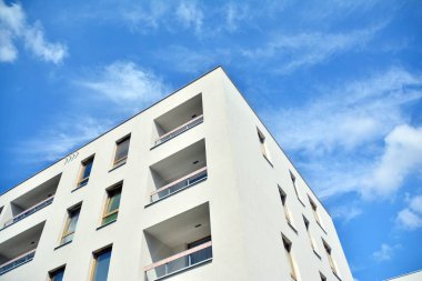 Mavi gökyüzü ve bulutlar ile modern daire binası. Modern çok katlı lüks konut konsepti.