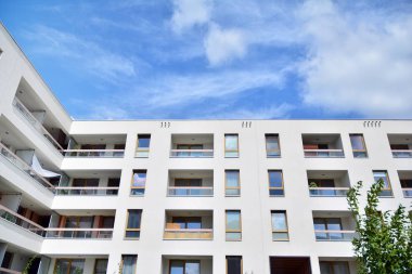 Mavi gökyüzü ve bulutlar ile modern daire binası. Modern çok katlı lüks konut konsepti.