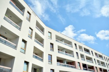 Mavi gökyüzü ve bulutlar ile modern daire binası. Modern çok katlı lüks konut konsepti.