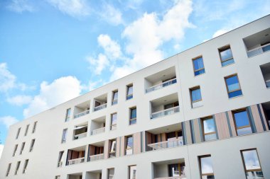 Mavi gökyüzü ve bulutlar ile modern daire binası. Modern çok katlı lüks konut konsepti.