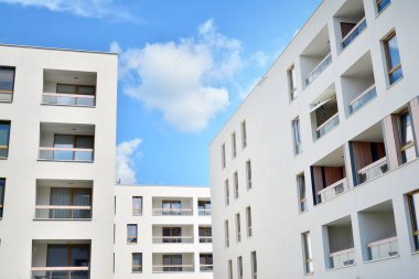 Mavi gökyüzü ve bulutlar ile modern daire binası. Modern çok katlı lüks konut konsepti.