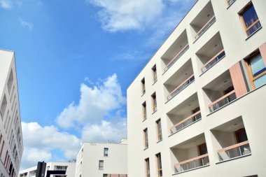 Mavi gökyüzü ve bulutlar ile modern daire binası. Modern çok katlı lüks konut konsepti.