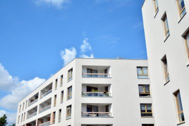Mavi gökyüzü ve bulutlar ile modern daire binası. Modern çok katlı lüks konut konsepti.