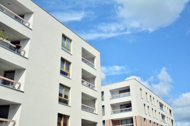 Mavi gökyüzü ve bulutlar ile modern daire binası. Modern çok katlı lüks konut konsepti.