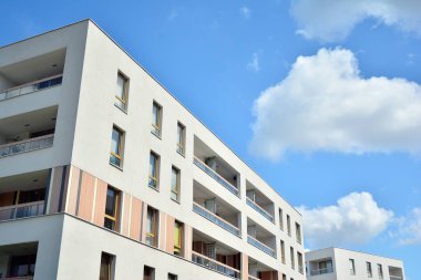 Mavi gökyüzü ve bulutlar ile modern daire binası. Modern çok katlı lüks konut konsepti.
