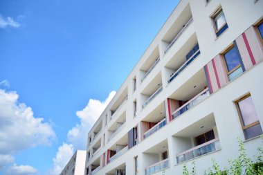 Mavi gökyüzü ve bulutlar ile modern daire binası. Modern çok katlı lüks konut konsepti.