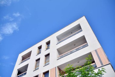 Mavi gökyüzü ve bulutlar ile modern daire binası. Modern çok katlı lüks konut konsepti.