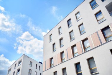 Mavi gökyüzü ve bulutlar ile modern daire binası. Modern çok katlı lüks konut konsepti.