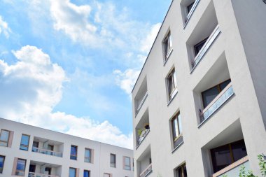 Mavi gökyüzü ve bulutlar ile modern daire binası. Modern çok katlı lüks konut konsepti.