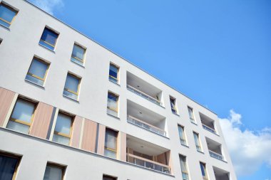 Mavi gökyüzü ve bulutlar ile modern daire binası. Modern çok katlı lüks konut konsepti.