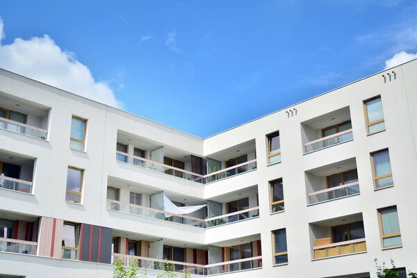 Modern apartment building with blue sky and clouds. Modern multi-storey luxury housing concept.