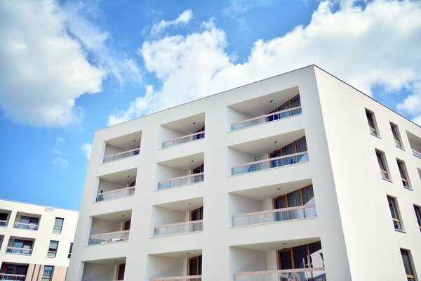 Modern apartment building with blue sky and clouds. Modern multi-storey luxury housing concept.