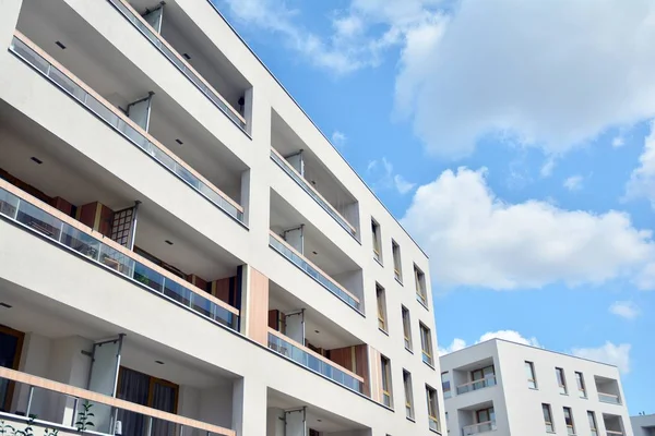 Mavi gökyüzü ve bulutlar ile modern daire binası. Modern çok katlı lüks konut konsepti.