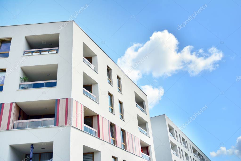 Modern apartment building with blue sky and clouds. Modern multi-storey luxury housing concept.