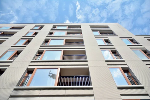 Gündüz gözüyle modern yerleşim yerinin dış tarafında. Mavi gökyüzü olan güneşli bir günde modern apartman binaları. Modern bir apartmanın cephesi