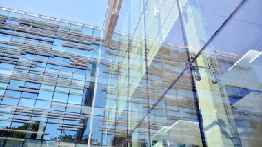  Binanın pencerelerinde yansıması ile Modern ofis binası. Şehir merkezinde yeni ofis binası.