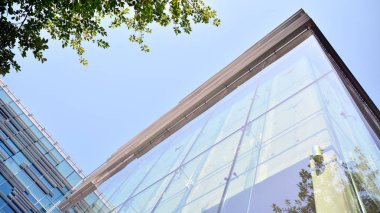  Binanın pencerelerinde yansıması ile Modern ofis binası. Şehir merkezinde yeni ofis binası.