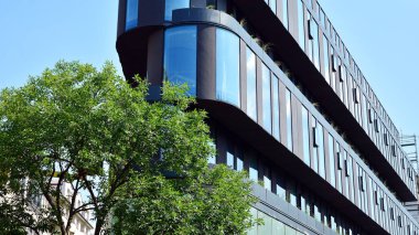  Binanın pencerelerinde yansıması ile Modern ofis binası. Şehir merkezinde yeni ofis binası.