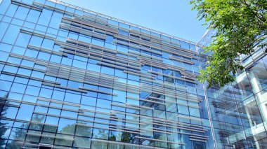  Binanın pencerelerinde yansıması ile Modern ofis binası. Şehir merkezinde yeni ofis binası.