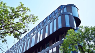  Binanın pencerelerinde yansıması ile Modern ofis binası. Şehir merkezinde yeni ofis binası.