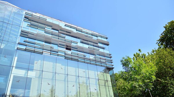  Современное офисное здание с отражением в окнах здания. Новое офисное здание в центре города
.