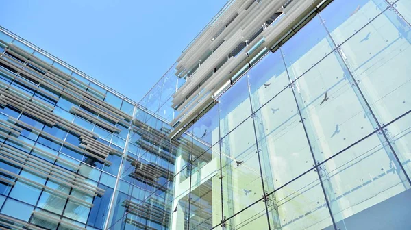  Binanın pencerelerinde yansıması ile Modern ofis binası. Şehir merkezinde yeni ofis binası.