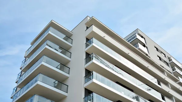 Gündüz gözüyle modern yerleşim yerinin dış tarafında. Mavi gökyüzü olan güneşli bir günde modern apartman binaları. Modern bir apartmanın cephesi