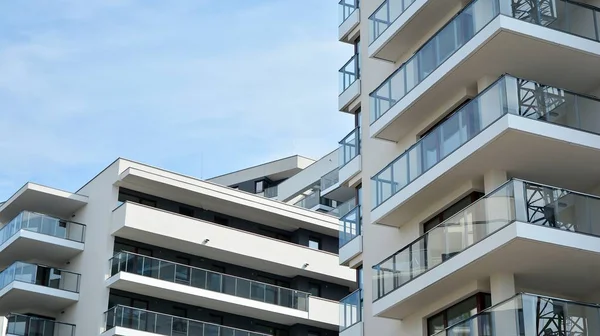 Gündüz gözüyle modern yerleşim yerinin dış tarafında. Mavi gökyüzü olan güneşli bir günde modern apartman binaları. Modern bir apartmanın cephesi