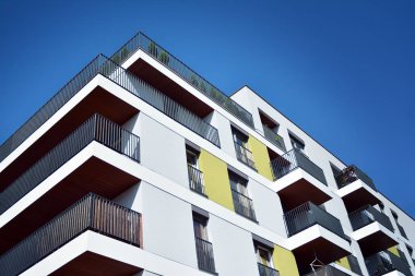 Mavi gökyüzü olan güneşli bir günde modern apartman binaları. Modern bir apartmanın cephesi