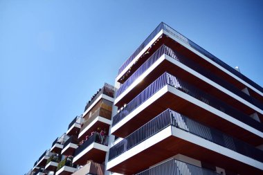 Mavi gökyüzü olan güneşli bir günde modern apartman binaları. Modern bir apartmanın cephesi