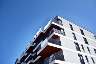 Mavi gökyüzü olan güneşli bir günde modern apartman binaları. Modern bir apartmanın cephesi