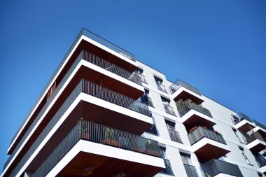 Mavi gökyüzü olan güneşli bir günde modern apartman binaları. Modern bir apartmanın cephesi