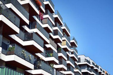 Mavi gökyüzü olan güneşli bir günde modern apartman binaları. Modern bir apartmanın cephesi
