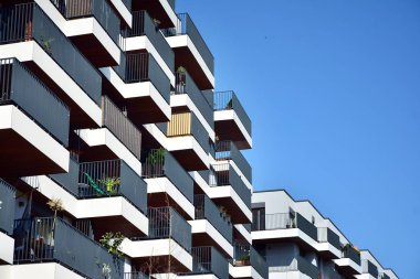Mavi gökyüzü olan güneşli bir günde modern apartman binaları. Modern bir apartmanın cephesi