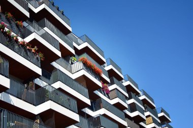 Mavi gökyüzü olan güneşli bir günde modern apartman binaları. Modern bir apartmanın cephesi
