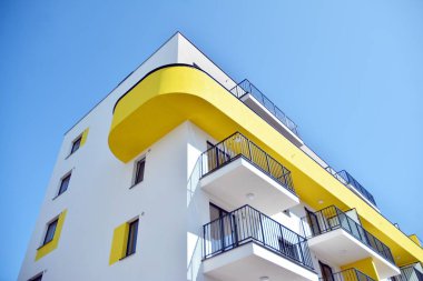 Mavi gökyüzü olan güneşli bir günde modern apartman binaları. Modern bir apartmanın cephesi