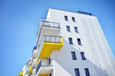 Mavi gökyüzü olan güneşli bir günde modern apartman binaları. Modern bir apartmanın cephesi