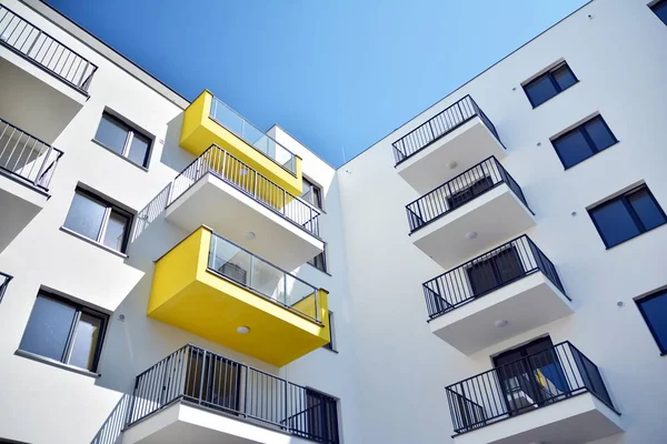 Mavi gökyüzü olan güneşli bir günde modern apartman binaları. Modern bir apartmanın cephesi