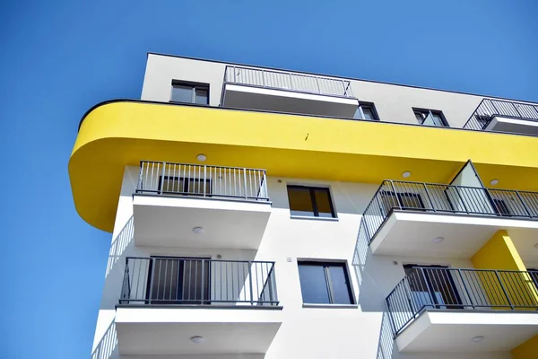 Mavi gökyüzü olan güneşli bir günde modern apartman binaları. Modern bir apartmanın cephesi