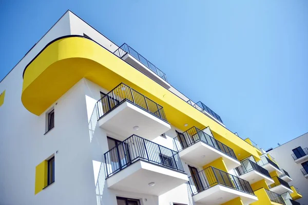Mavi gökyüzü olan güneşli bir günde modern apartman binaları. Modern bir apartmanın cephesi