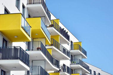 Mavi gökyüzü olan güneşli bir günde modern apartman binaları. Modern bir apartmanın cephesi