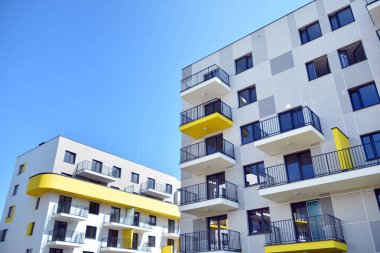 Mavi gökyüzü olan güneşli bir günde modern apartman binaları. Modern bir apartmanın cephesi