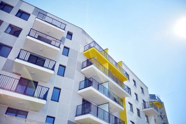 Mavi gökyüzü olan güneşli bir günde modern apartman binaları. Modern bir apartmanın cephesi
