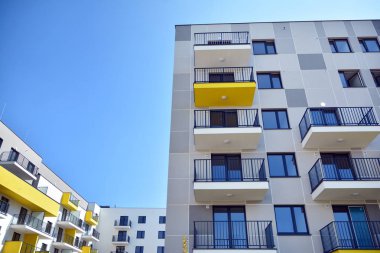 Mavi gökyüzü olan güneşli bir günde modern apartman binaları. Modern bir apartmanın cephesi