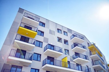 Mavi gökyüzü olan güneşli bir günde modern apartman binaları. Modern bir apartmanın cephesi