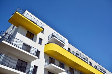 Mavi gökyüzü olan güneşli bir günde modern apartman binaları. Modern bir apartmanın cephesi