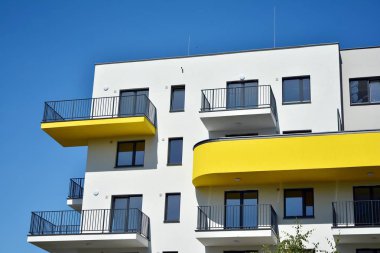 Mavi gökyüzü olan güneşli bir günde modern apartman binaları. Modern bir apartmanın cephesi