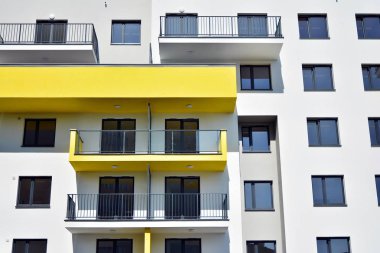 Mavi gökyüzü olan güneşli bir günde modern apartman binaları. Modern bir apartmanın cephesi